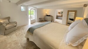 Une chambre à coucher avec un grand lit, un canapé, une commode et un miroir.