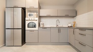 A modern kitchen with a built-in refrigerator, oven, microwave, and sink.
