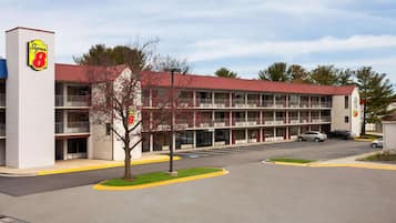 A motel with a red roof and multiple balconies.