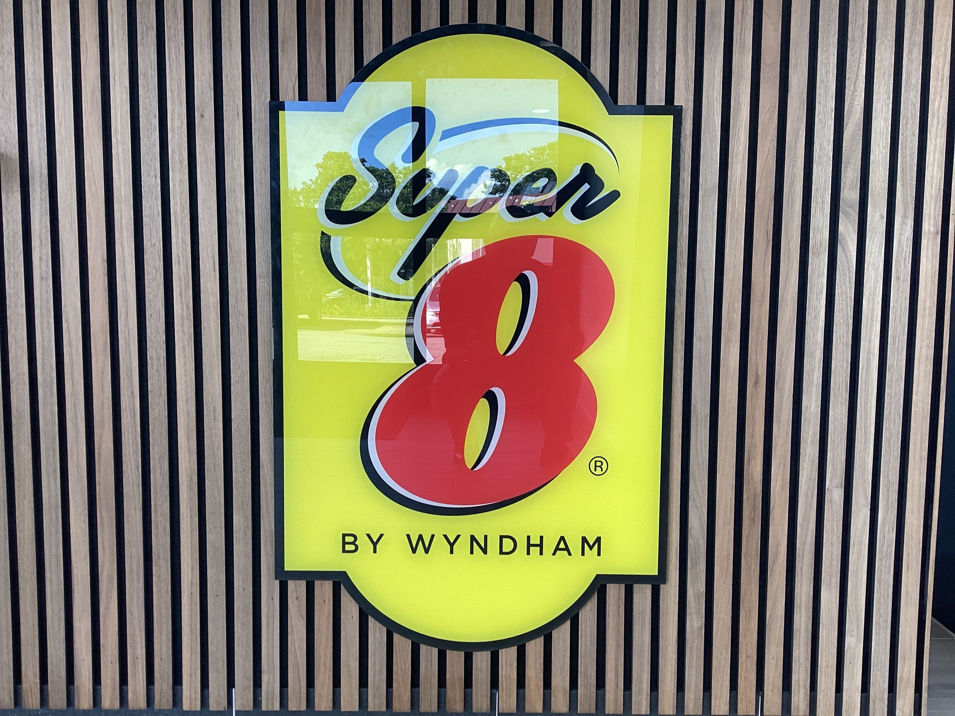 En logotyp med texten ”Super 8” och ”By Wyndham” mot en gul bakgrund.