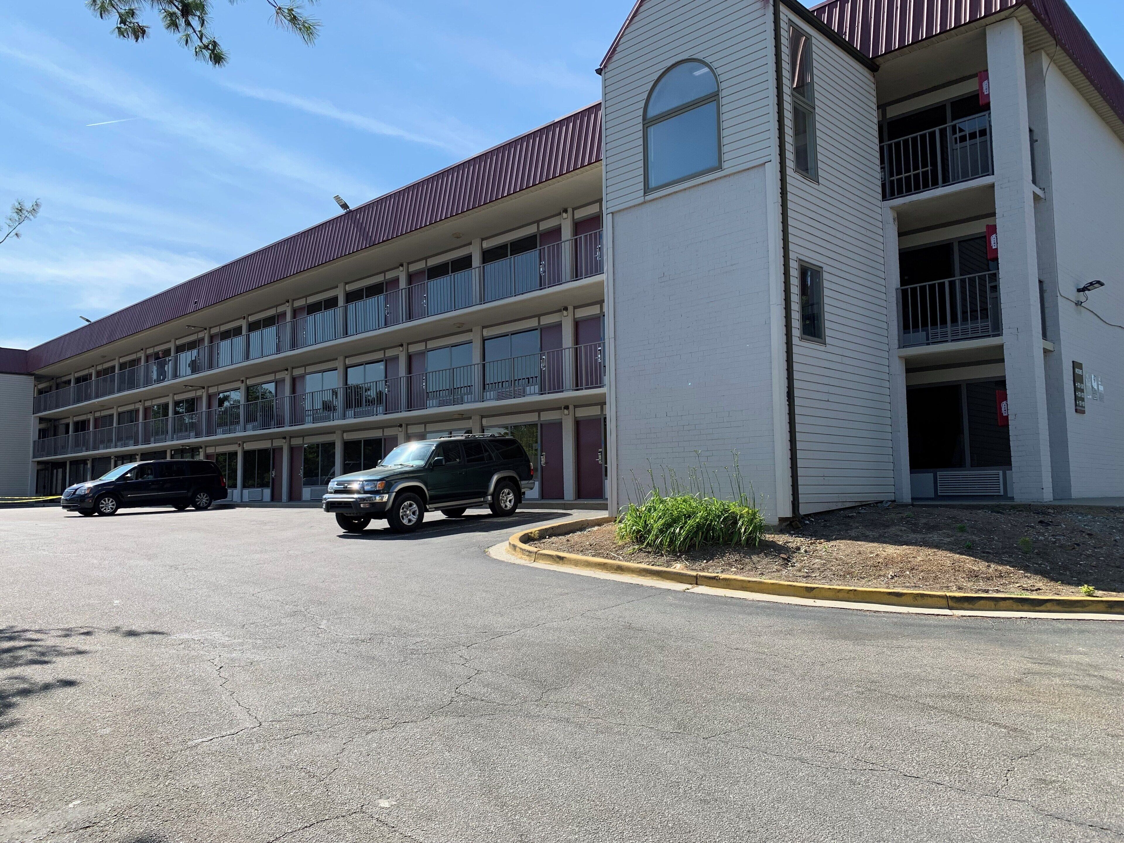 A multi-story motel with a parking lot.