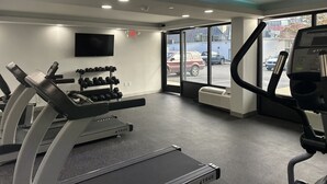 A gym with treadmills, dumbbells, and a TV on the wall. - Super 8 By Wyndham Baltimore Northwest (Baltimore)
