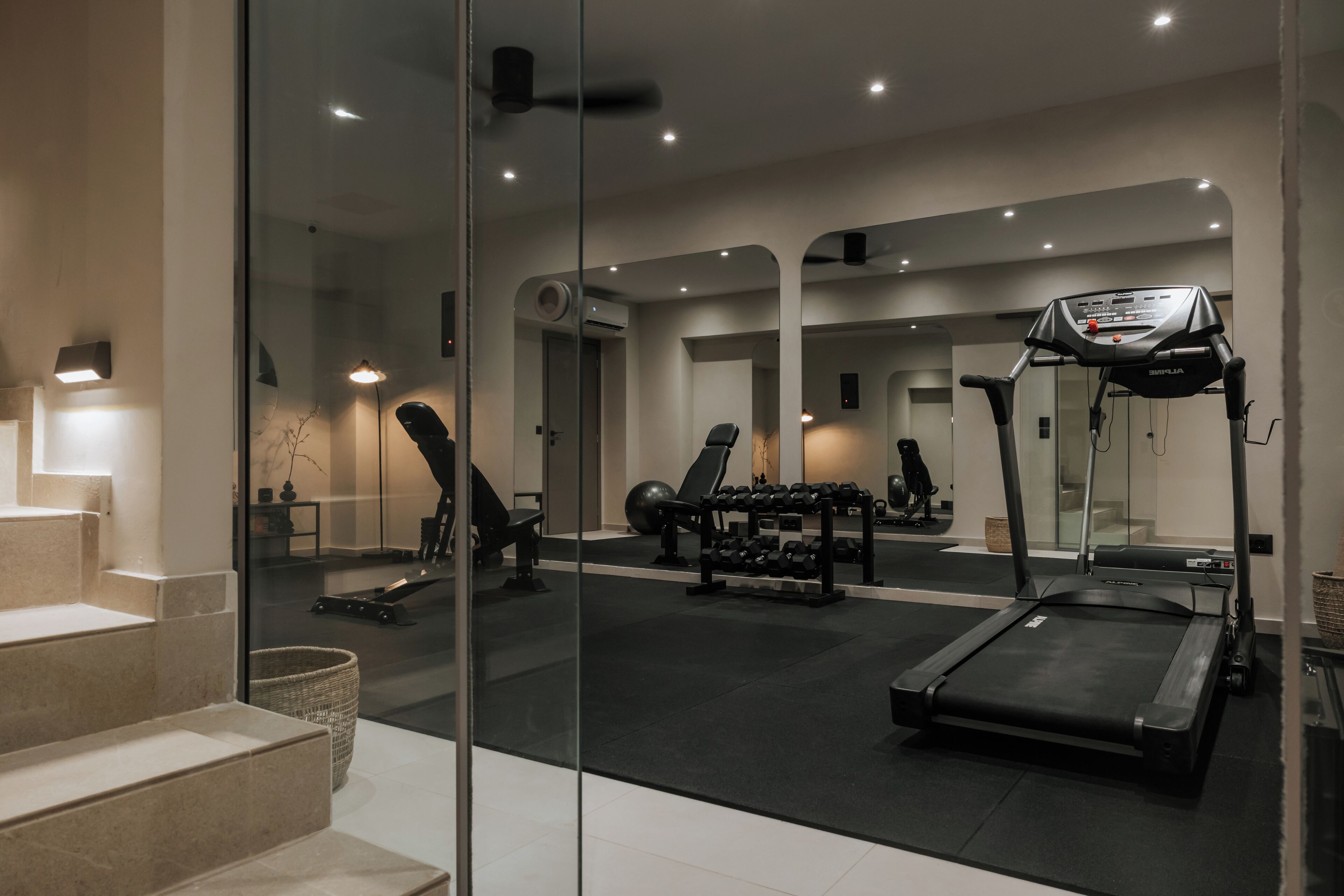 A modern home gym with a treadmill, weights, and exercise equipment.