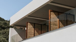 A modern building with a flat roof, large windows, and a balcony with wooden slats. - AMÉNTE Mindful Stay (Agios Vasileios)