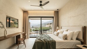 A modern bedroom with a bed, a desk, and a chair. There is a window with a view of the outdoors. - AMÉNTE Mindful Stay (Agios Vasileios)