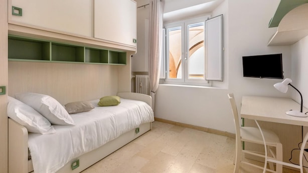 A compact bedroom with a bed, a desk, and a TV. - Primula Apartment by Wonderful Italy (Bologna)