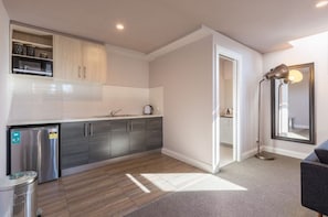 Compact kitchen with ample storage, stainless steel appliances, and a microwave.
