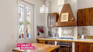 A kitchen with wooden cabinets, a gas stove, and a dining table with chairs. - Country Style House in Bologna by Wonderful Italy (Bologna)