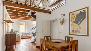 A dining area with a wooden table and chairs, a hanging plant, and a wall-mounted decorative item. - Country Style House in Bologna by Wonderful Italy (Bologna)
