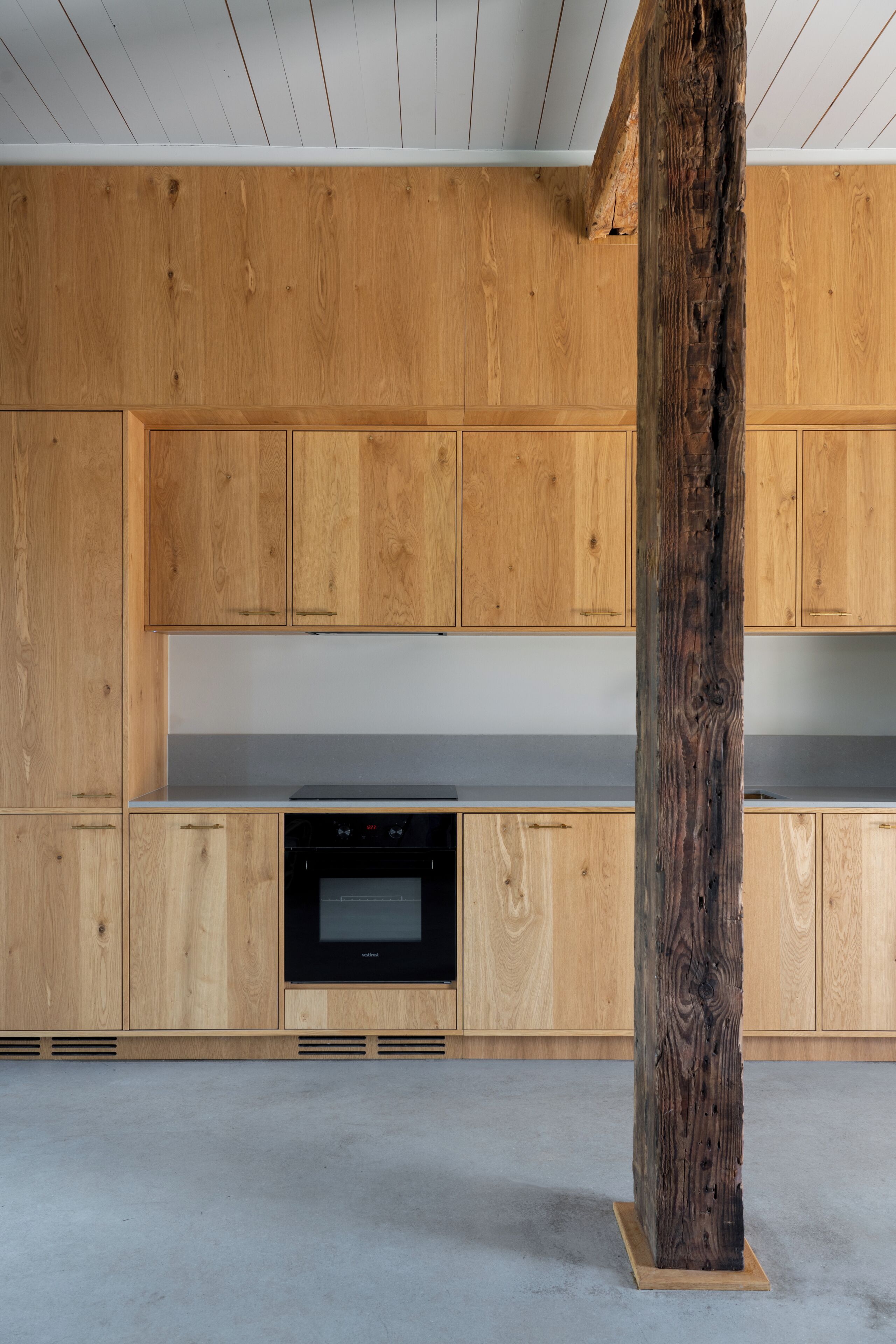 A modern kitchen with wooden cabinetry and a central island.