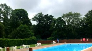 En swimmingpool med ett trädäck, en tavla och utomhusmöbler.