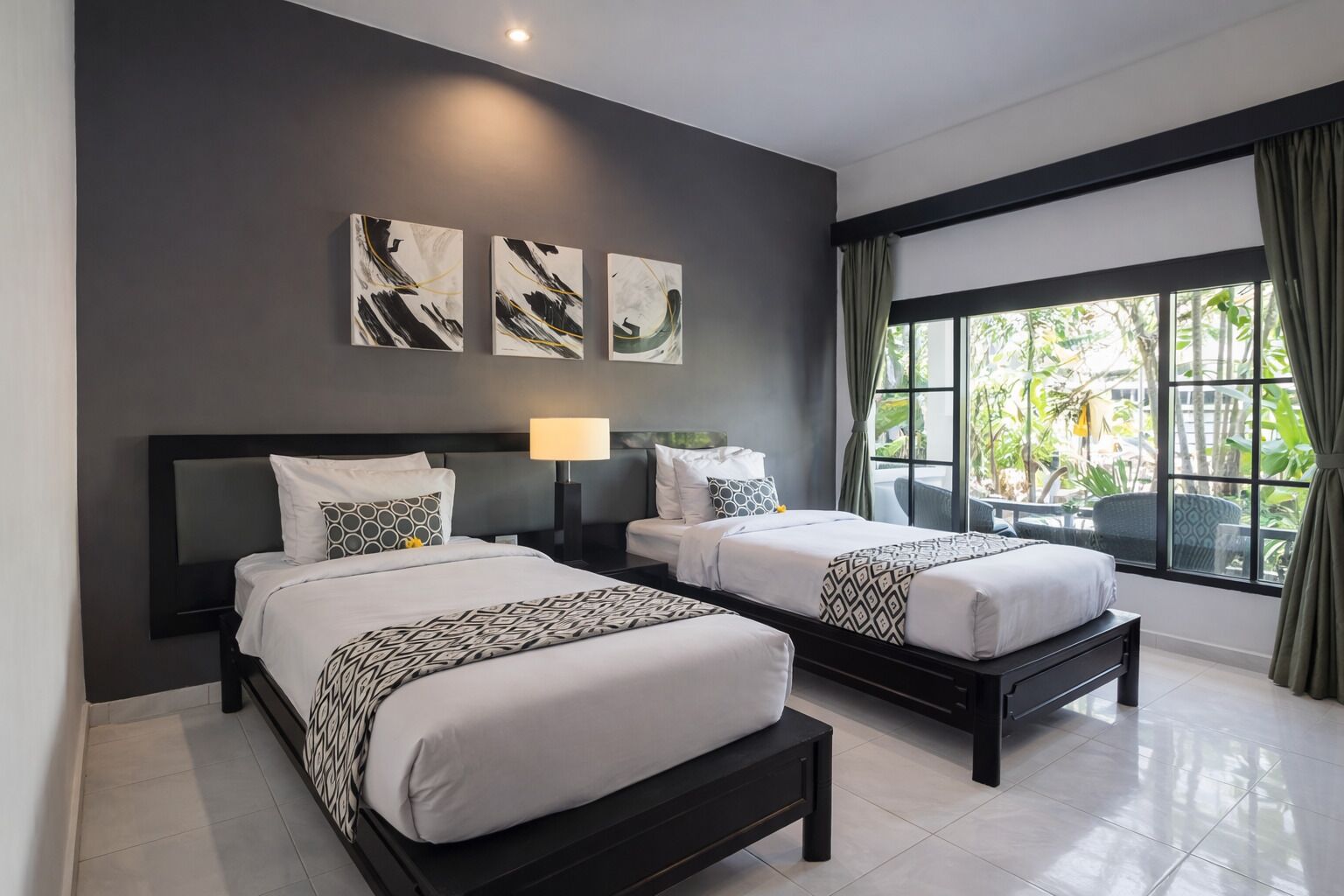Habitación de hotel con dos camas, un ventanal con cortinas y una obra de arte en la pared.