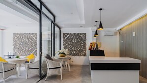 A modern interior with a dining area, a reception desk, and decorative wall panels. - Casa Wina Kuta (Kuta)
