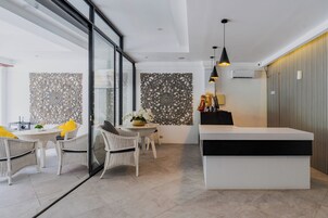 Un interior moderno con zona de comedor, mostrador de recepción y paneles decorativos en la pared.