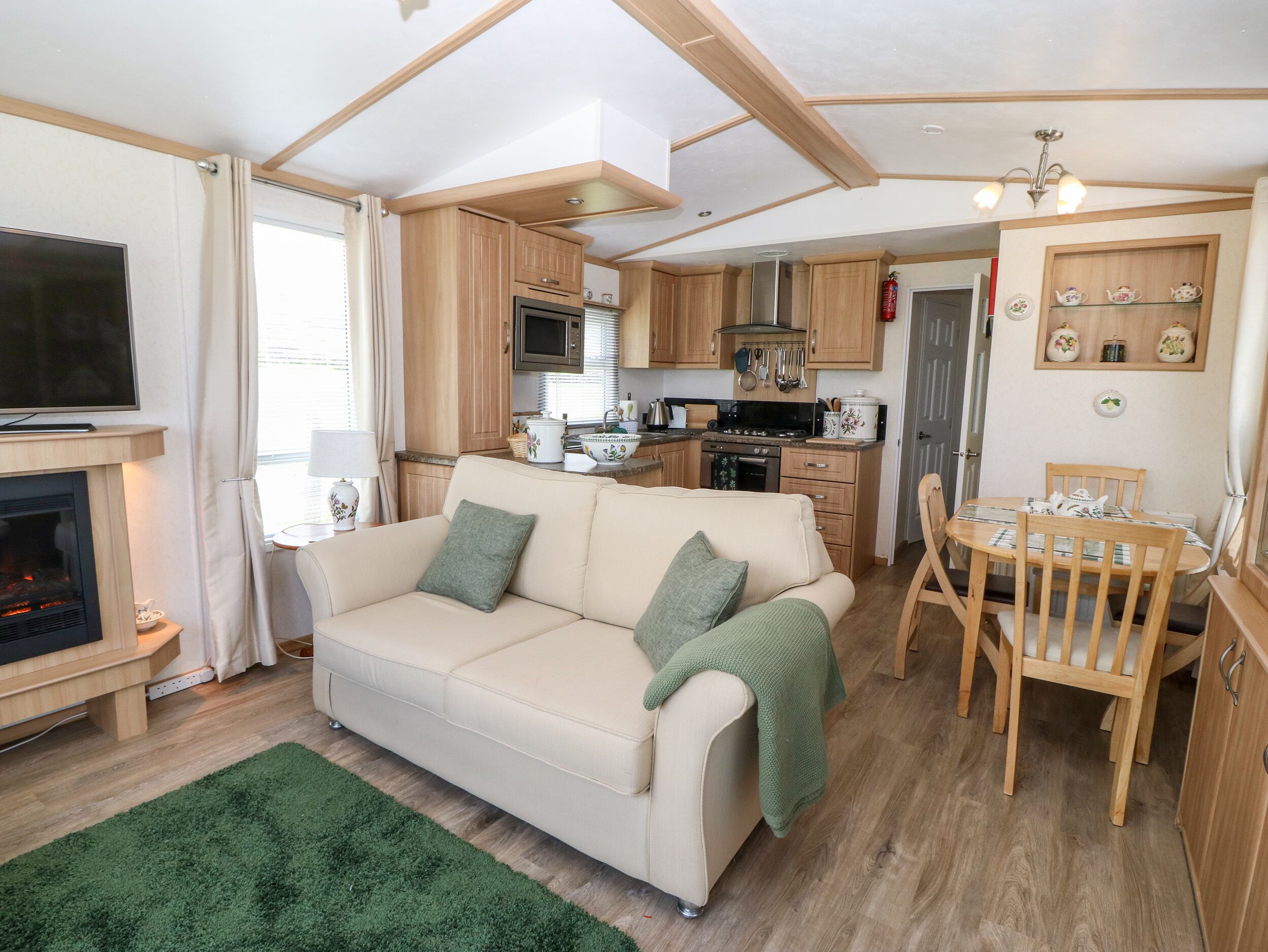 A cozy living area with a sofa, a dining table, and a kitchen in the background.