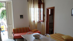 Una habitación compacta con una mesa de comedor, un sofá y una cama.