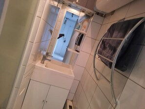 Une salle de bain équipée d’un lavabo, d’un miroir et d’un porte-serviettes.