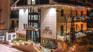 Un hotel con diseño arquitectónico moderno, que presenta una entrada destacada con fachada de vidrio y un balcón.