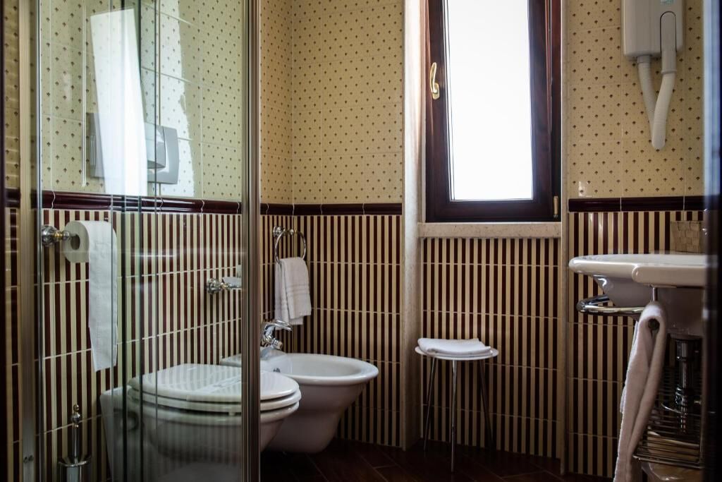 A bathroom with a toilet, bidet, and sink.
