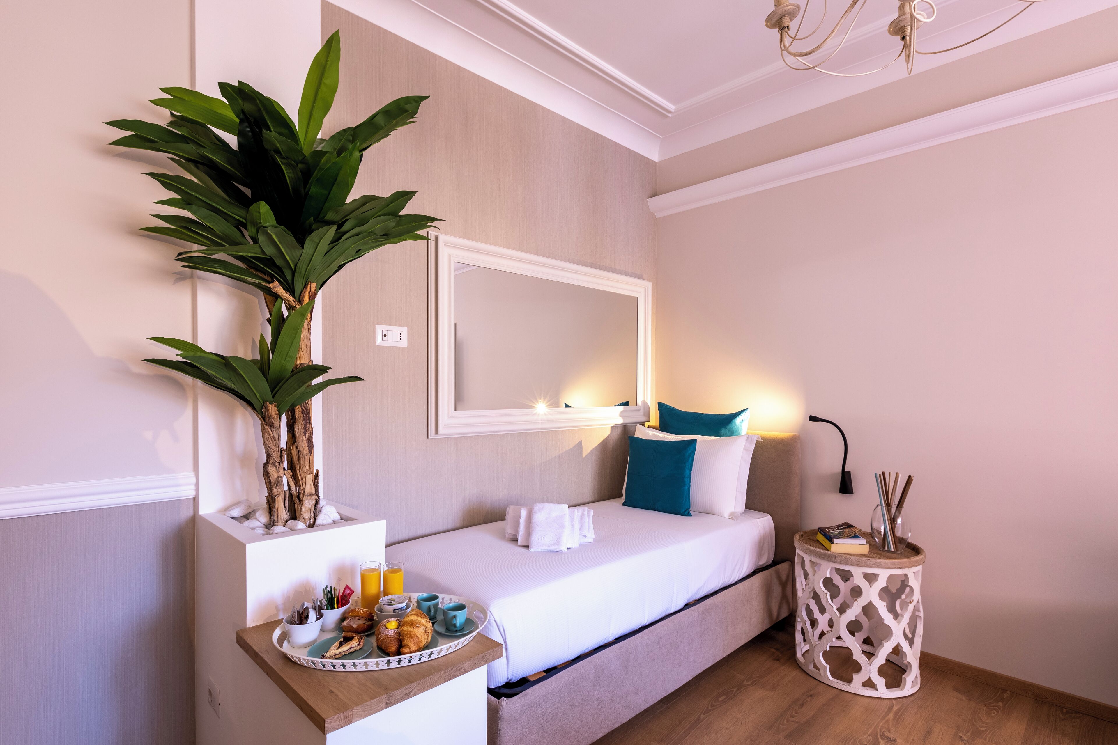 Une chambre bien rangée, avec un lit, une table de chevet et une plante en pot.