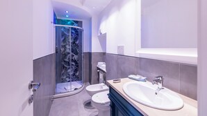 A modern bathroom with a glass shower enclosure, a large sink, and a toilet. - Trastevere Paper Suites (Rome)
