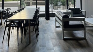A modern conference room with a long table and chairs, large windows, and a view of the outside. - Luxury Studio in San Telmo (Buenos Aires)