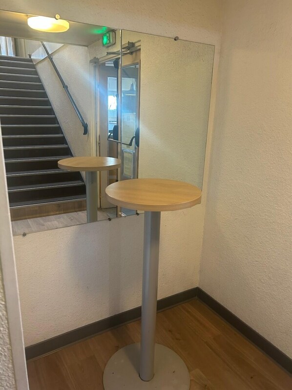 Un rincón con una mesa de madera y un espejo en la pared.