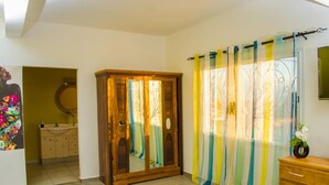 A room with a wooden wardrobe, a mirror, a sink, and a wooden cabinet. - Room in Villa - Comfortable and Welcoming Suite With Terrace Overlooking the Lake (Antananarivo)