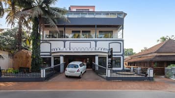 Un edificio de dos plantas con un automóvil estacionado adelante.