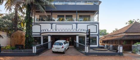 A two-story building with a car parked in front.