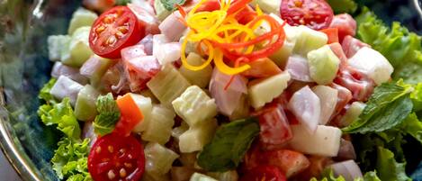 A bowl of salad with various vegetables and a decorative garnish.