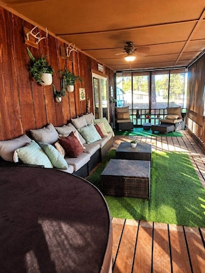 A cozy indoor seating area with a sofa, ottomans, and potted plants.