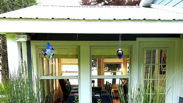 A small, single-story house with a porch. - Beautiful Huron Bay sunsets from your own private beach. (Skanee)