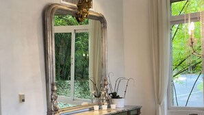 A room with a large mirror, a wooden vanity, and a window with a view of greenery. - Srvittinivillas Aptla F1 Best Loc and View / Lux / Altos D Chavon/ Cdc (La Romana)