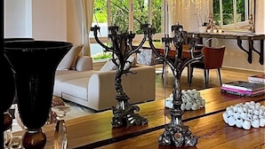 A modern living room with a wooden coffee table, a sofa, and a dining area with a chandelier. - Srvittinivillas Aptla F1 Best Loc and View / Lux / Altos D Chavon/ Cdc (La Romana)