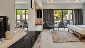 Habitación de hotel con cama, escritorio con televisor, silla y vistas al exterior.