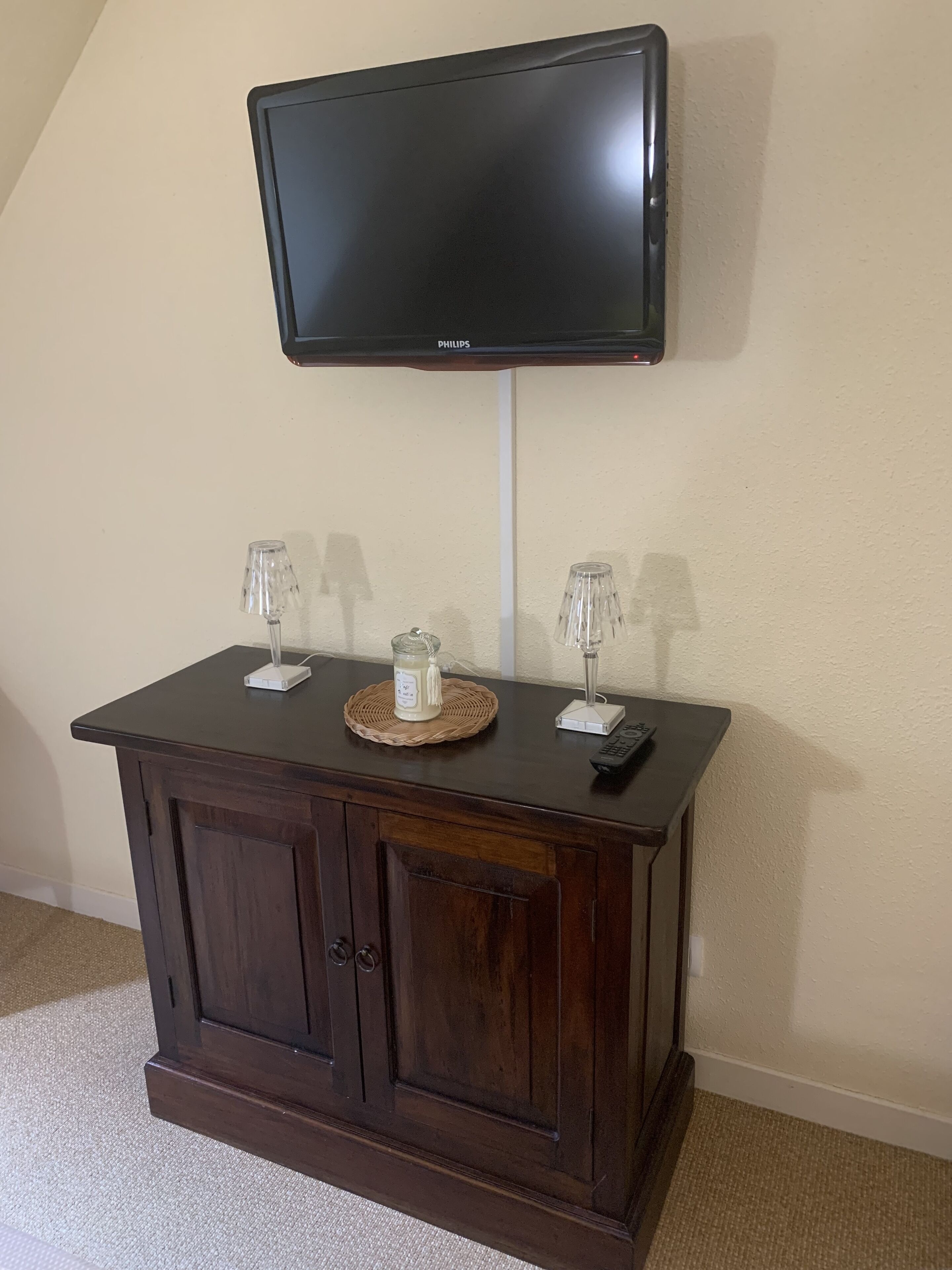Een donker houten kast met een flatscreen televisie erboven.