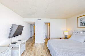 A hotel room with a bed, a TV, a desk, and a nightstand.