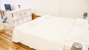 A neatly arranged bedroom with a bed, a desk, and a chair. - Apartamento / Estudio no Centro de Lisboa Para Casal ou Família (Lisboa)