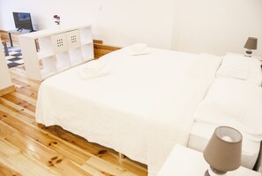 Quarto bem arrumado com uma cama, uma escrivaninha e uma cadeira.