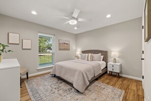 A bedroom with a bed, nightstands, a ceiling fan, and a window with blinds. - Pecan Grove: Stroll Downtown Frisco (Frisco)