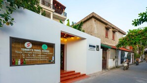 Un bâtiment moderne avec une enseigne indiquant « Tommy's Travel Service », proposant des circuits touristiques et des transferts privés.