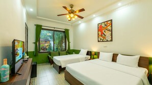 Une chambre d’hôtel avec deux lits simples, un ventilateur de plafond, une télévision et une fenêtre avec des rideaux verts.