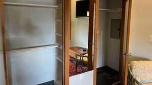 A room with a wardrobe, a bed, and a small table with a chair. - Unique studio with cozy patio (La Mesa)