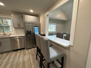 Enjoy cooking in this well-equipped kitchen with stainless steel appliances, a dining area, and a window for natural light.