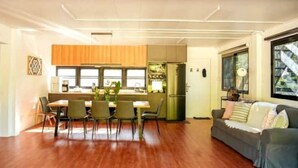 Ein modernes Wohnzimmer mit Essbereich, Holzboden und einer Couch.