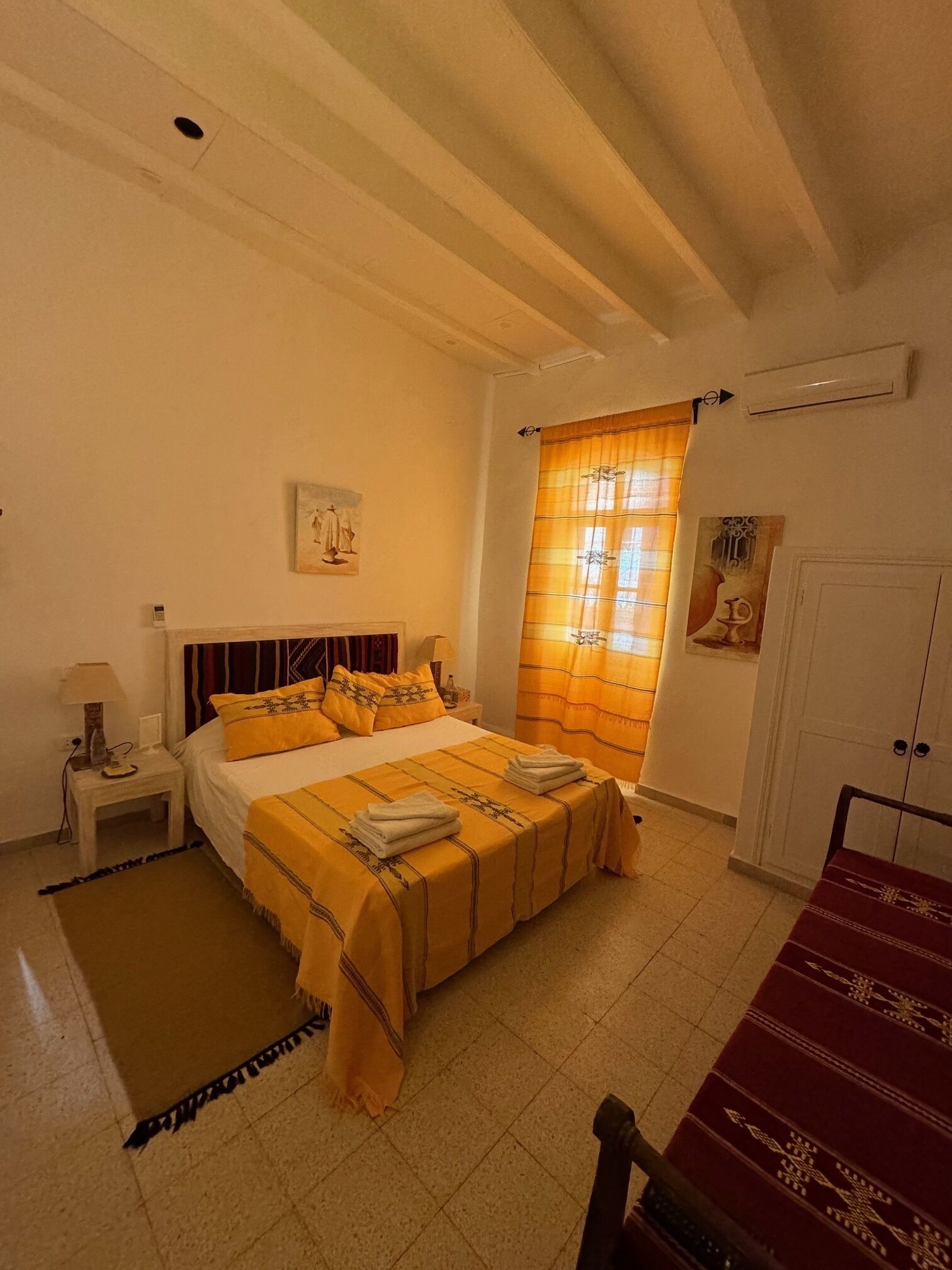 Une chambre à coucher avec un lit, une table de chevet et une armoire.