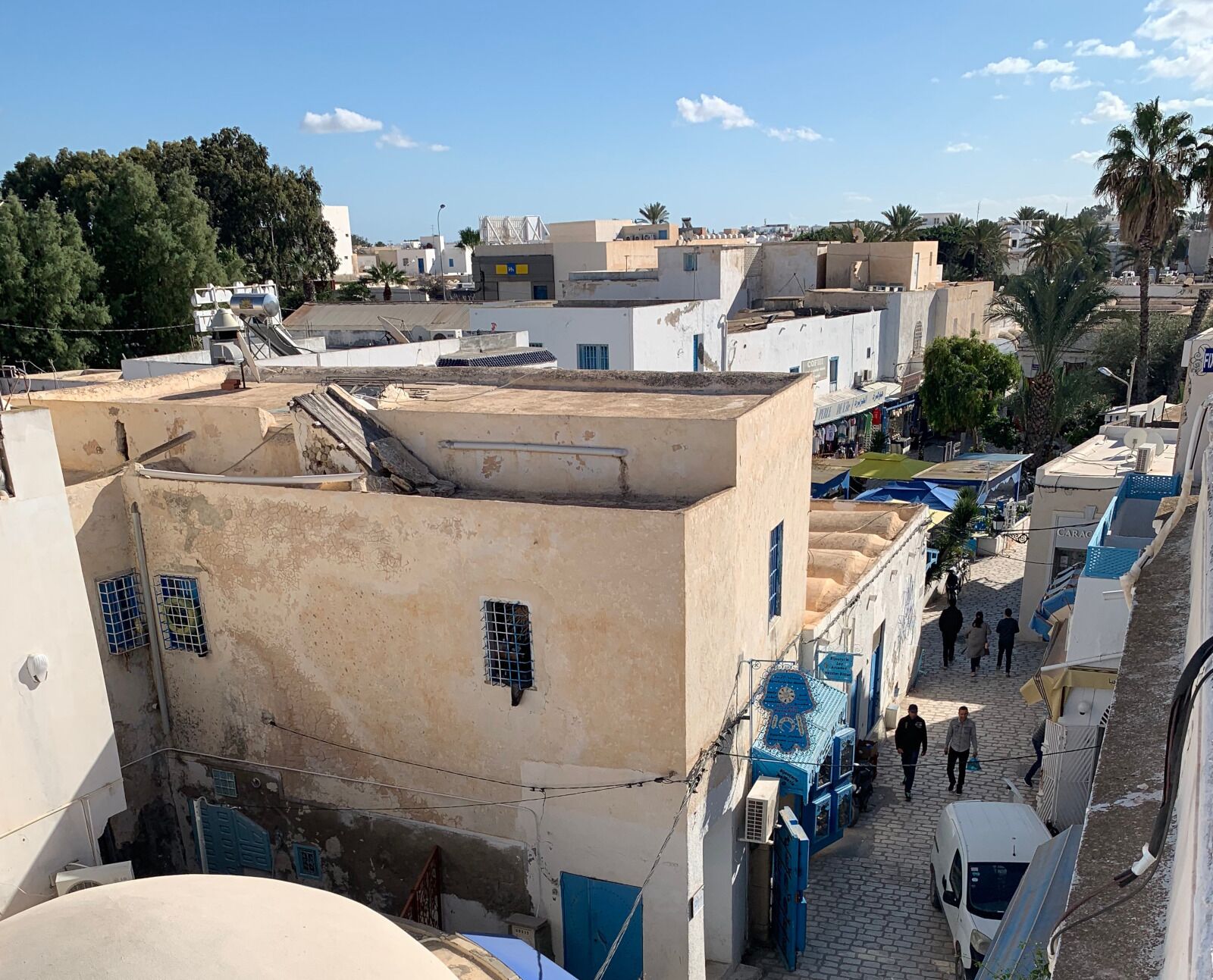 A narrow street with buildings on both sides, featuring a mix of residential and commercial properties.