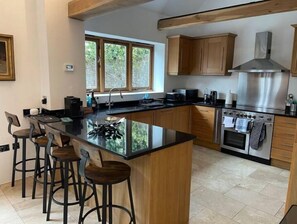 Enjoy cooking and dining in this kitchen with a large island, bar stools, and stainless steel appliances.