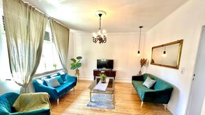 A living room with two sofas, a coffee table, a TV, and a chandelier. - Old villa in the heart of Lorsch (Lorsch)